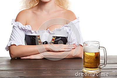 Beautiful young blond girl in traditional costume drinks out of oktoberfest beer stein. Stock Photo