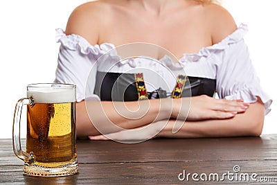 Beautiful young blond girl in traditional costume drinks out of oktoberfest beer stein. Stock Photo