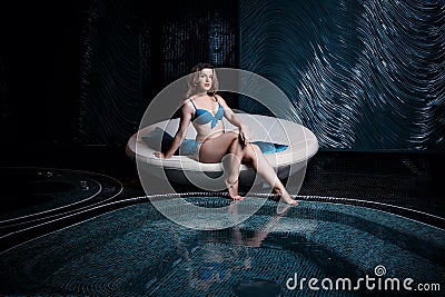 Beautiful young blonde caucasian woman in bikini relaxing in hot pool or jacuzzi at spa center Stock Photo