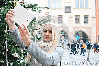 A beautiful young blonde woman or girl doing selfie or photographing. Stock Photo