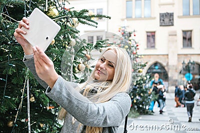 A beautiful young blonde woman or girl doing selfie or photographing. Stock Photo