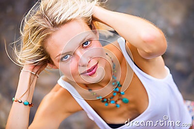 Beautiful young blonde woman posing outdoor at the rocky sea shore Stock Photo