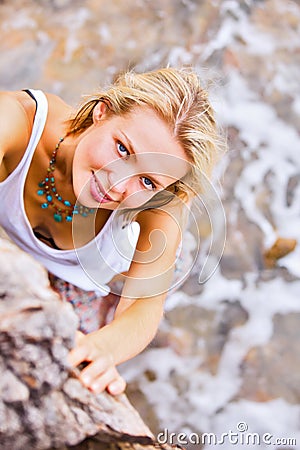 Beautiful young blonde woman posing outdoor at the rocky sea shore Stock Photo