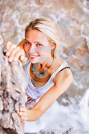 Beautiful young blonde woman posing outdoor at the rocky sea shore Stock Photo