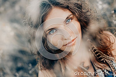 Beautiful young boho styled woman on a field at sunset Stock Photo