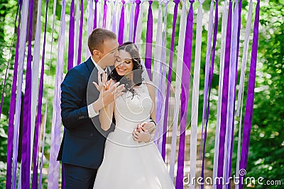 Beautiful young bride and groom at a wedding ceremony when in the background of multi-colored ribbons, marriage, relationships, c Stock Photo