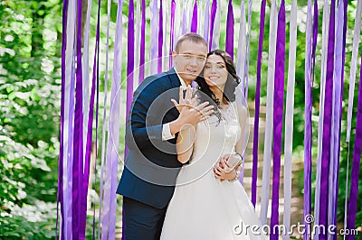 Beautiful young bride and groom at a wedding ceremony when in the background of multi-colored ribbons, marriage, relationships, c Stock Photo