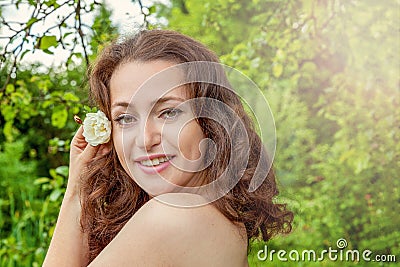 Girl with white rose flower in her hand in park Stock Photo