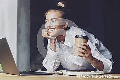 Beautiful young business woman working remotely from home. Smiling woman sits in front of laptop Stock Photo