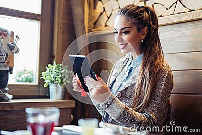 Beautiful young businesswoman in the cafe, using digital tablet and drinking coffee smiling Stock Photo