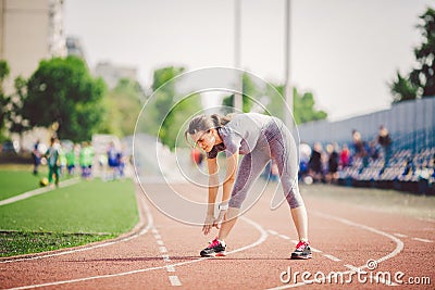 Beautiful young caucasian woman with long hair in tail and big breasts doing exercises, warming up and warming up muscles before t Stock Photo