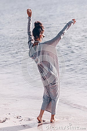 Beautiful young cheerful fashion model having fun on the beach at sunset Stock Photo