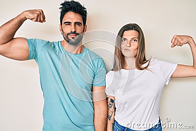 Beautiful young couple of boyfriend and girlfriend together strong person showing arm muscle, confident and proud of power Stock Photo