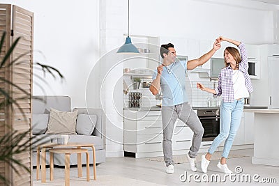 Beautiful young couple dancing in kitchen Stock Photo