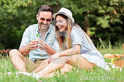 Beautiful young couple making a wish after finding four leaf clover Stock Photo