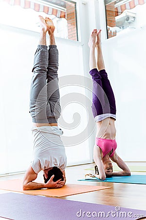 Beautiful young couple practicing yoga at home. Stock Photo