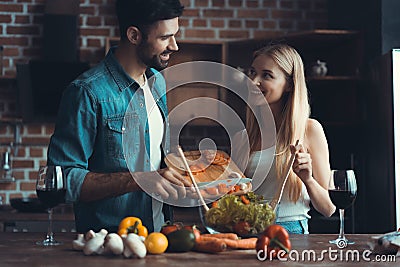 Beautiful young couple preparing a healthy meal together while spending free time at home. Stock Photo