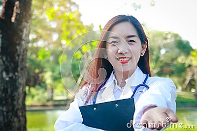 A beautiful Asian doctor standing in the garden Stock Photo