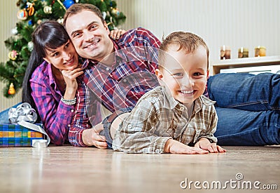 Beautiful young family under the christmas tree at home Stock Photo