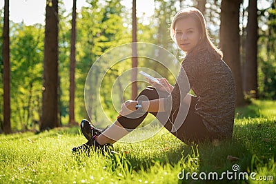 Beautiful young female athlete using fitness app on her smart watch to monitor workout performance. Lifestyle wearable technology. Stock Photo