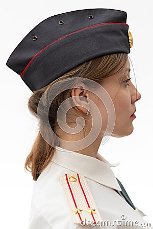 A beautiful young female Russian police officer in dress uniform in a cap and shoulder straps of a lieutenant colonel and a white Stock Photo