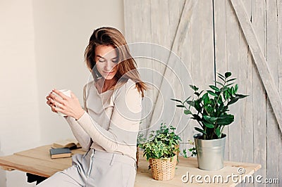 Beautiful young feminine woman relaxing at home in lazy weekend morning with cup of coffee Stock Photo