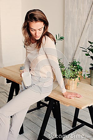 Beautiful young feminine woman relaxing at home in lazy weekend morning with cup of coffee Stock Photo