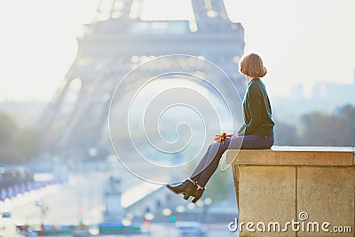 Beautiful young French woman near the Eiffel tower in Paris Stock Photo