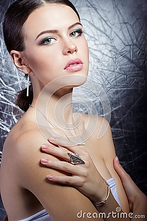 Beautiful young girl with beautiful stylish expensive jewelry, necklace, earrings, bracelet, ring, filming in the Studio Stock Photo