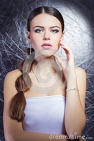 Beautiful young girl with beautiful stylish expensive jewelry, necklace, earrings, bracelet, ring, filming in the Studio Stock Photo