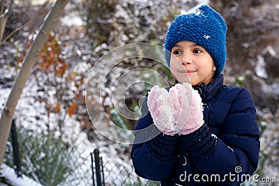 Beautiful young girl playing with snow in park Stock Photo