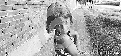 Beautiful young girl bulging her eyes at the camera. Black and white photo of a stylish girl. The child performs Stock Photo