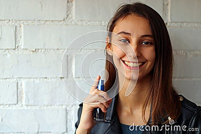 Beautiful young girl dressed in black, spraying perfume Stock Photo