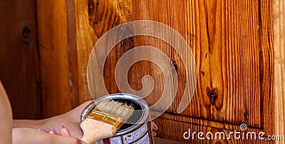 Beautiful young girl paints a wooden door. Summer work in the garden Stock Photo