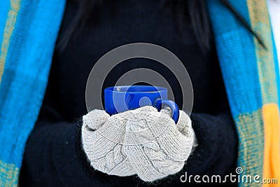 Beautiful young girl portrait on winter background. A charming young lady walking in a winter forest. Attractive woman with Cup. Stock Photo