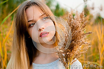 Beautiful young girl posing against high grass Stock Photo