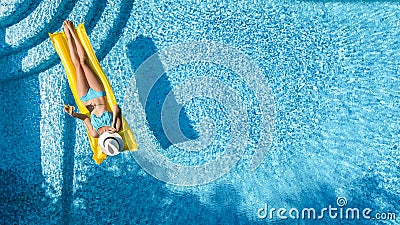 Beautiful young girl relaxing in swimming pool, swims on inflatable mattress and has fun in water on family vacation Stock Photo