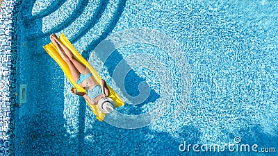 Beautiful young girl relaxing in swimming pool, swims on inflatable mattress and has fun in water on family vacation Stock Photo