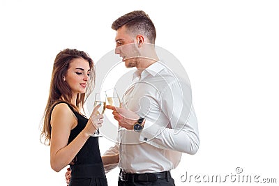 Beautiful young girl stands next to an attractive young man and drinking Champagne Stock Photo