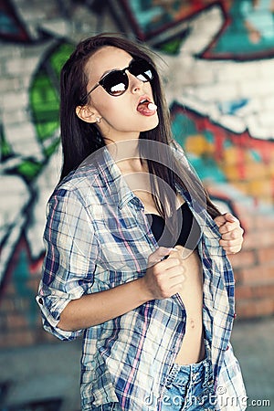 Beautiful young girl in sunglasses is going to swallow pills. Stock Photo
