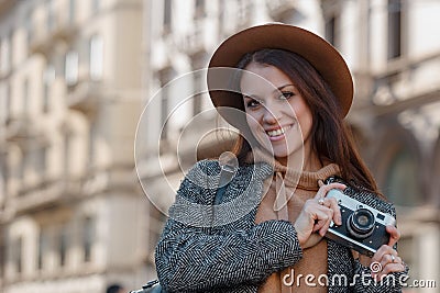 Beautiful young girl tourist holds a camera in his hands and looks into the frame Stock Photo