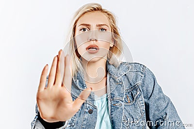 Beautiful young girl unhappy frown and says stop with a hand gesture on gray isolated background Stock Photo