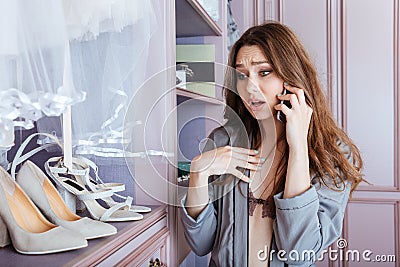 Beautiful young girl using mobile phone in a wardrobe Stock Photo