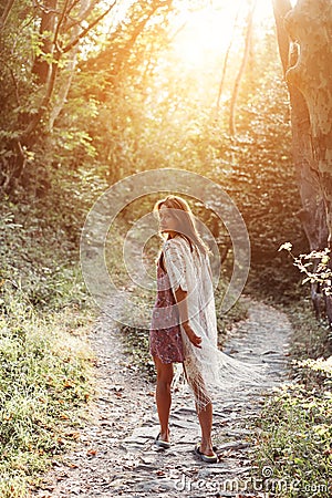Beautiful, young girl walks at the foot of the mountain along Stock Photo