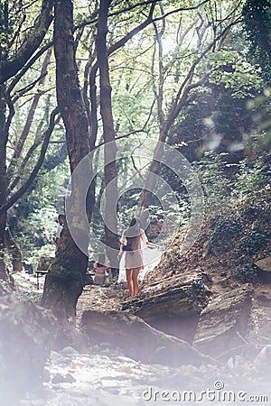 Beautiful, young girl walks at the foot of the mountain along Stock Photo