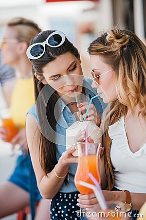 beautiful young girlfriends drinking summer cocktail together Stock Photo