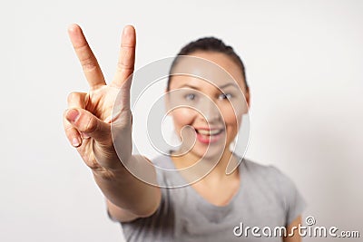 Beautiful young happy smiling girl showing victopy sing with her hand. Peace concept. Sign of gestures Stock Photo