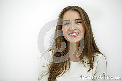 Beautiful young happy woman posing against a white wall Stock Photo