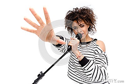 Beautiful young heavy metal singer with microphone singing and gesturing Stock Photo