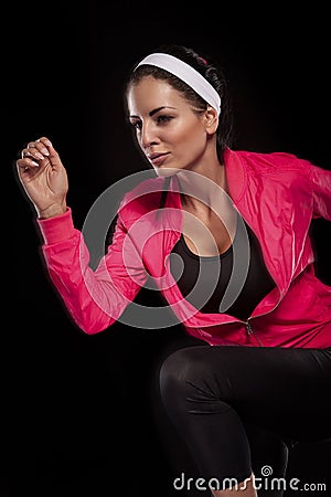 Beautiful young jogging woman isolated over black background (colored, retouched) Stock Photo